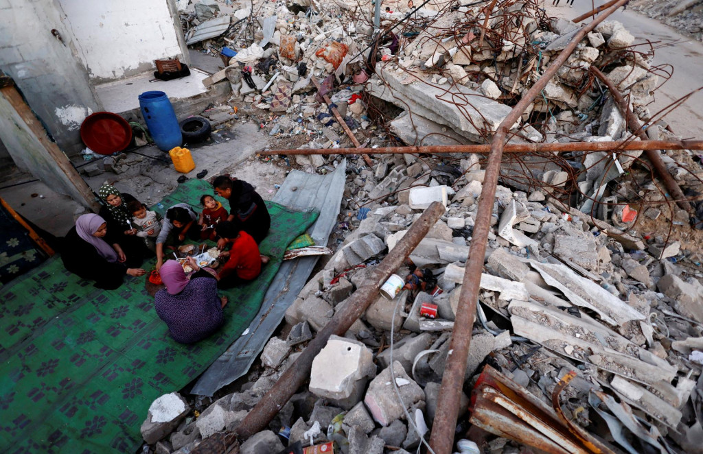 Palestínčania prerušujú pôst uprostred trosiek svojho zničeného domova počas moslimského svätého pôstneho mesiaca ramadánu v Rafahu v južnom Pásme Gazy. FOTO: Reuters