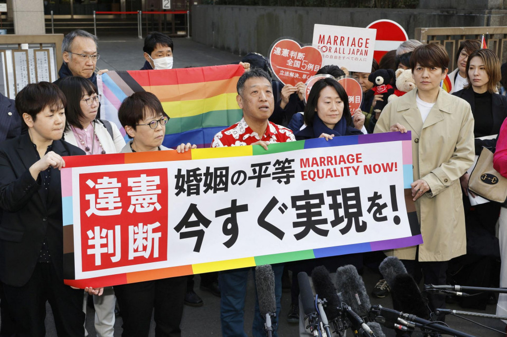 Žalobcovia a aktivisti v prípade manželskej rovnosti v Japonsku držia transparent s nápisom „Neústavné“. FOTO: Reuters/Kyodo