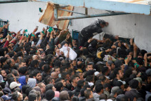 Palestínčania sa zhromažďujú, aby dostali pomoc pred skladom UNRWA. FOTO: Reuters
