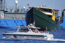 Loď čínskej pobrežnej stráže prechádza okolo filipínskeho plavidla. FOTO: TASR/AP