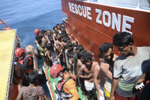 Rohingskí utečenci, ktorých loď sa potopila, nastupujú na palubu záchrannej lode pri pobreží indonézskej provincie Aceh. FOTO: TASR/AP