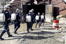 Zamestnanci ministerstva kráčajú do bane na zlato vo východnej časti Ruska, v ktorej uviazlo najmenej 13 baníkov. FOTO: TASR/AP