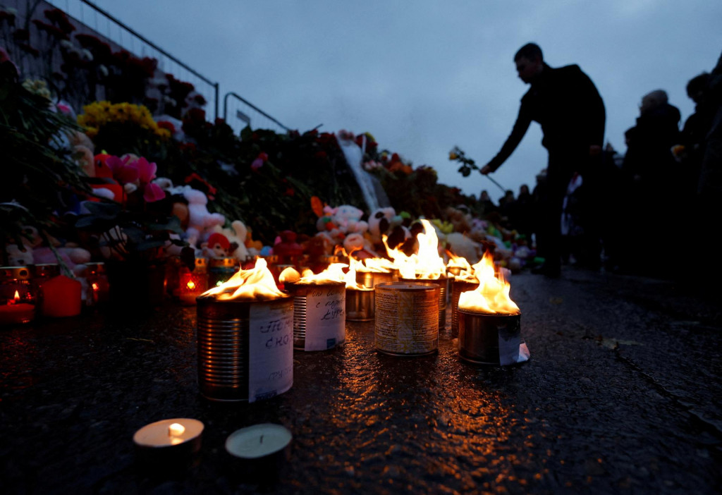Muž kladie kvety k provizórnemu pamätníku obetiam, ktorý sa nachádza pri koncertnej sále Crocus City Hall v Moskovskej oblasti. FOTO: Reuters