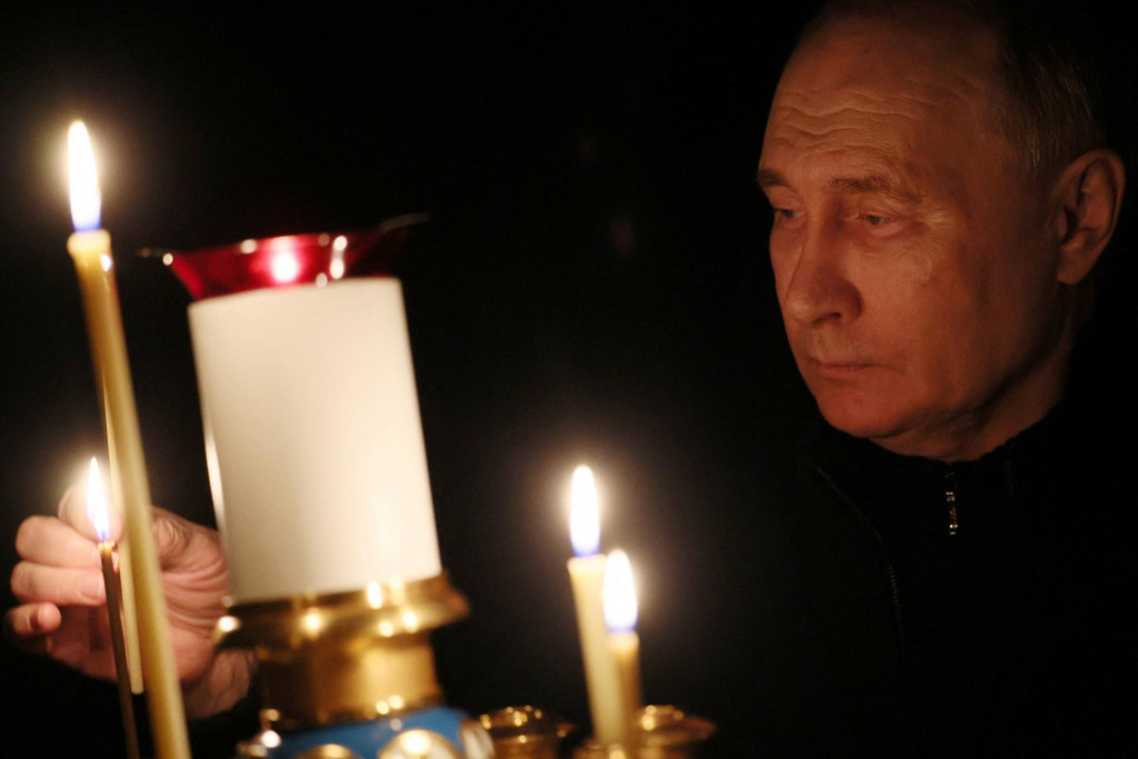 Ruský prezident Vladimir Putin zapaľuje sviečku na pamiatku obetí útoku v deň štátneho smútku v kostole v štátnej rezidencii Novo-Ogaryovo pri Moskve v Rusku. FOTO: REUTERS