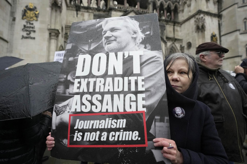 Demonštrantka drží transparent s podobizňou zakladateľa servera WikiLeaks Juliana Assangea pred budovou súdu v Londýne. FOTO TASR/AP