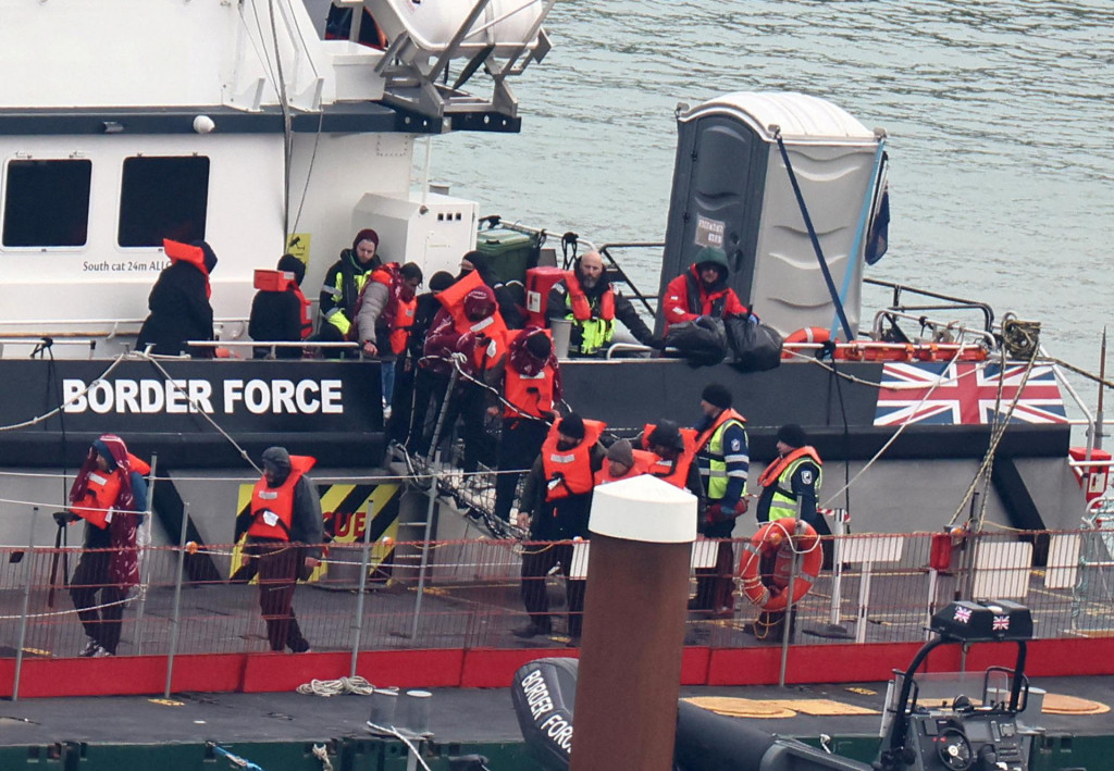 Migranti vystupujú z lode britských pohraničných síl pri príchode do prístavu Dover. FOTO: Reuters