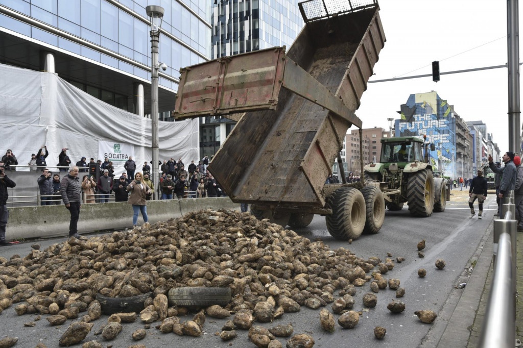 Farmár na traktore vysypáva zemiaky na hlavnom bulvári neďaleko budovy Európskej rady v Bruseli. FOTO: TASR/AP
