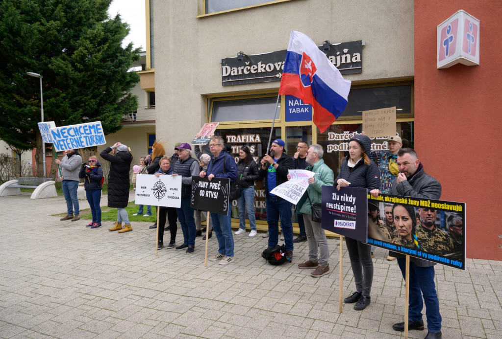 Protestujúci stoja pred mestským kultúrnym domom počas príchodu ministrov na výjazdové zasadnutie vlády v Galante. FOTO: TASR/Henrich Mišovič
