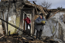 71-ročná Inna drží nájdené potraviny pred svojím domom, ktorý bol zničený počas ruského leteckého útoku v meste Záporožie na juhovýchode Ukrajiny. FOTO: TASR/AP