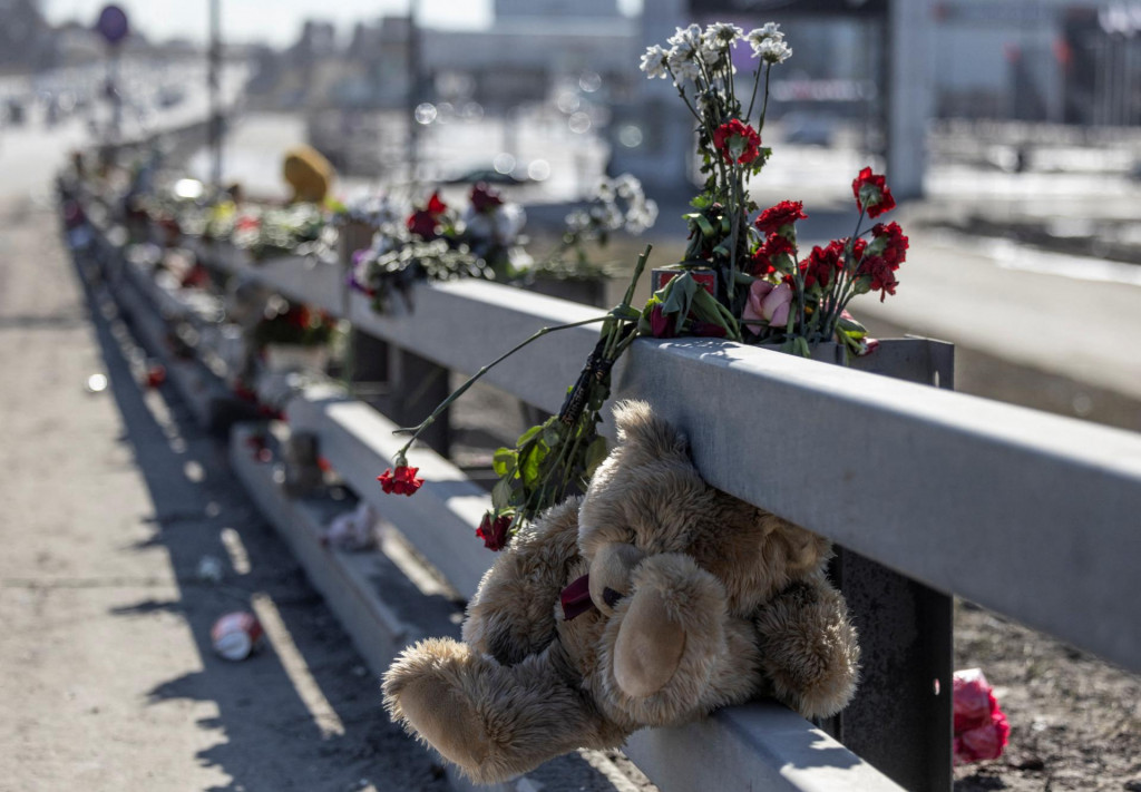 Kvety a hračky sú umiestnené na okraji cesty pred vyhoreným centrom Crocus City Hall. FOTO: Reuters