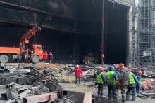 Záchranári pracujú na mieste zhorenej koncertnej sály na predmestí Moskvy. FOTO: TASR/AP