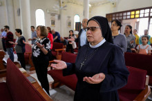 Mníška sa modlí, keď sa palestínski kresťania zúčastňujú veľkonočnej omše v kostole Svätej rodiny počas tlmených slávností. FOTO: Reuters