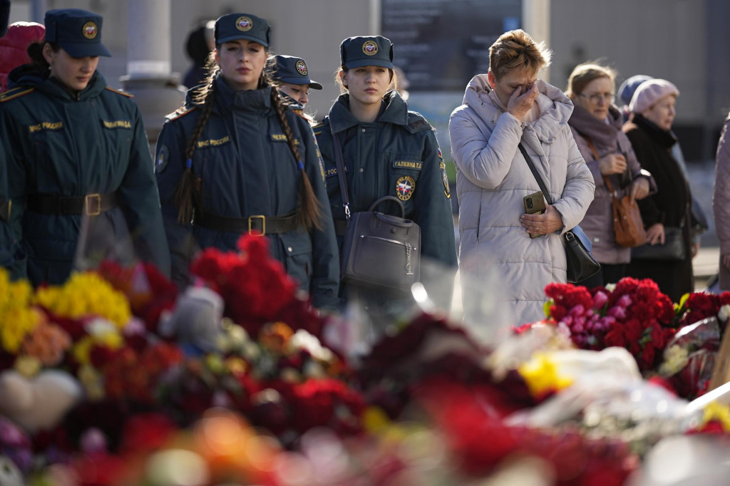 Ľudia stoja pri provizórnom pamätníku pred koncertou sálou na predmestí Moskvy. FOTO: TASR/AP