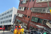 Hasiči zasahujú v blízkosti budovy, ktorá sa zrútila následkom zemetrasenia. FOTO: Reuters