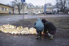 Ľudia zapaľujú sviečky a kladú kvety pred základnou školou Viertola vo Vantaa vo Fínsku. FOTO: TASR/AP