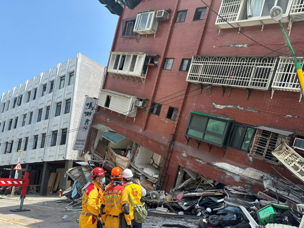 Hasiči zasahujú v blízkosti budovy, ktorá sa zrútila následkom zemetrasenia. FOTO: Reuters
