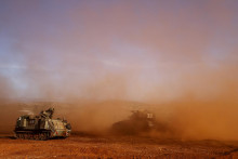 Izraelský obrnený transportér a izraelský tank sa zúčastňujú cvičenia pri hraniciach Izraela s Libanonom. FOTO: Reuters
