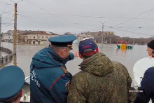 Ruský minister pre mimoriadne situácie Alexander Kurenkov (druhý zľava) stojí na člne a pozoruje hladinu vody po pretrhnutí hrádze v ruskom meste Orsk. FOTO: TASR/AP