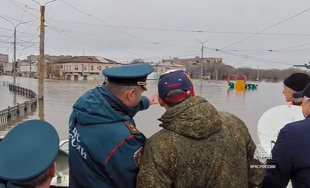 Ruský minister pre mimoriadne situácie Alexander Kurenkov (druhý zľava) stojí na člne a pozoruje hladinu vody po pretrhnutí hrádze v ruskom meste Orsk. FOTO: TASR/AP