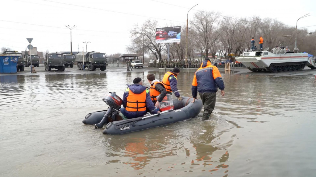 Záchranári jazdia na člne po zaplavenej ulici v Orsku v Rusku. FOTO: Reuters
