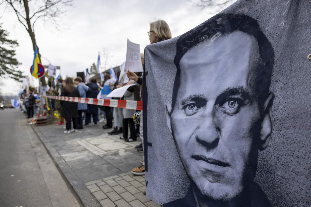 Ľudia držia transparent s podobizňou Alexeja Navaľného. FOTO: TASR/AP