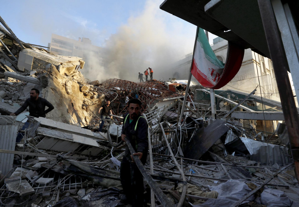 Príslušníci záchranných zložiek zasahujú po leteckom útoku v Damasku. FOTO: TASR/AP