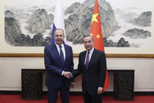 Ruský minister zahraničných vecí Sergej Lavrov (vľavo) si podáva ruku so svojím čínskym rezortným partnerom Wangom I počas ich stretnutia v Pekingu. FOTO: TASR/AP