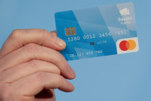 Muž drží v ruke platobnú kartu na tlačovej konferencii v Mníchove. FOTO: TASR/DPA