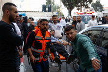 Ľudia prevážajú obete útoku izraelských osadníkov v dedine al-Mughayyir, v nemocnici v Ramalláhe na Izraelom okupovanom Západnom brehu Jordánu. FOTO: Reuters