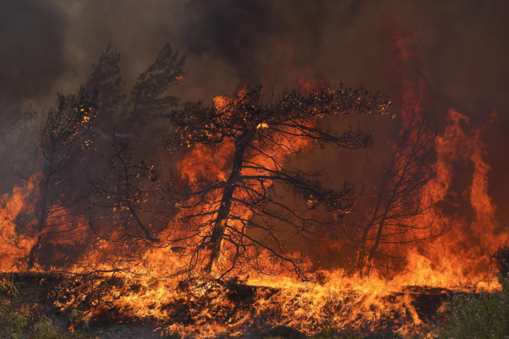 Na archívnej snímke z 25. júla 2023 plamene počas lesného požiaru na gréckom ostrove Rhodos