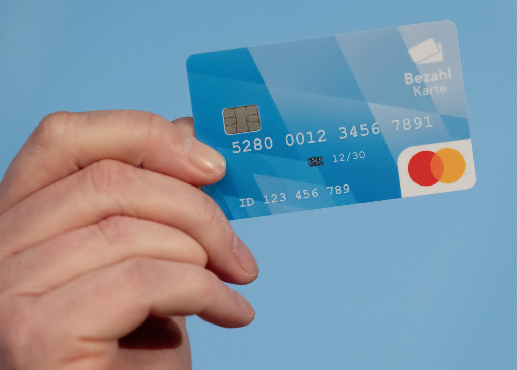 Muž drží v ruke platobnú kartu na tlačovej konferencii v Mníchove. FOTO: TASR/DPA