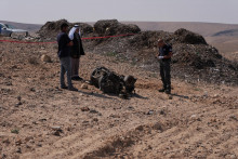 Policajt a obyvatelia kontrolujú pozostatky raketového posilňovača, ktorý podľa izraelských úradov kriticky zranil 7-ročné dievča po tom, čo Irán vypustil drony a rakety na Izrael. FOTO: Reuters