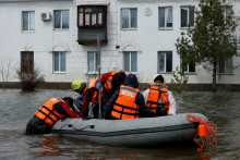 Záchranári vezú miestnych obyvateľov loďou na návštevu ich bytu v zaplavenej rezidenčnej štvrti v Orsku v Orenburskej oblasti. FOTO: Reuters