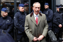 Čestný predseda strany Reform UK Nigel Farage stojí pred policajtmi v deň konferencie s názvom Národný konzervativizmus v Bruseli. FOTO: Reuters
