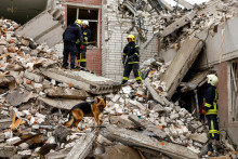 Záchranári pracujú na mieste zničenej budovy v Černihive. FOTO: Reuters