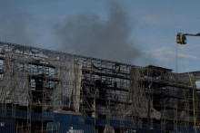 Hasiči pracujú na hasení stále tlejúceho ohňa v historickej budove burzy v Kodani. FOTO: Reuters