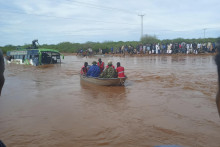 Cestujúci z potopeného autobusu sa plavia na loďke počas záplav následkom prudkých dažďov neďaleko mesta Garissa, na severe Kene. FOTO: TASR/AP