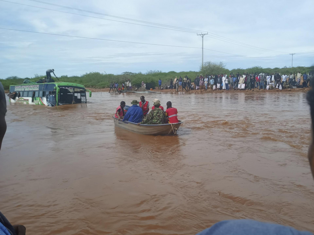 Cestujúci z potopeného autobusu sa plavia na loďke počas záplav následkom prudkých dažďov neďaleko mesta Garissa, na severe Kene. FOTO: TASR/AP