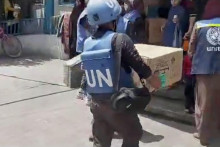 Pracovníci Organizácie Spojených národov a Organizácie Spojených národov pre pomoc a prácu nosia krabice s pomocou, ktoré rozdávajú vysídleným Palestínčanom. FOTO: Reuters