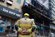 Hasiči stoja na mieste požiaru opusteného hotela v juhobrazílskom meste Porto Alegre. FOTO: Reuters