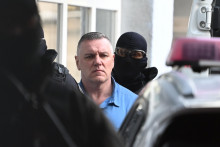 Na snímke odsúdený Mikuláš Černák prichádza v sprievode eskorty na verejné zasadnutie Okresného súdu Trnava v trestnej veci o návrhu na podmienečné prepustenie z výkonu trestu odňatia slobody.

FOTO: TASR