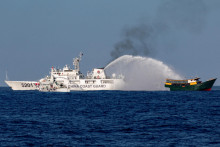 Plavidlá čínskej pobrežnej stráže strieľajú vodnými delami smerom k filipínskemu zásobovaciemu plavidlu v Juhočínskom mori. FOTO: Reuters