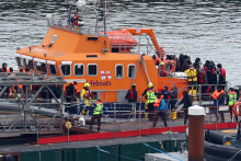 Ľudia, o ktorých sa predpokladá, že ide o migrantov, vystupujú zo záchranného člna v prístave Dover v Británii. FOTO: Reuters