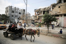 Palestínčania jazdia na vozíku vedľa miesta izraelského útoku na dom v Rafahu v južnom Pásme Gazy. FOTO: Reuters