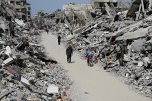 Palestínčania prechádzajú popri ruinách domov a budov zničených počas izraelskej vojenskej ofenzívy v severnom Pásme Gazy. FOTO: Reuters