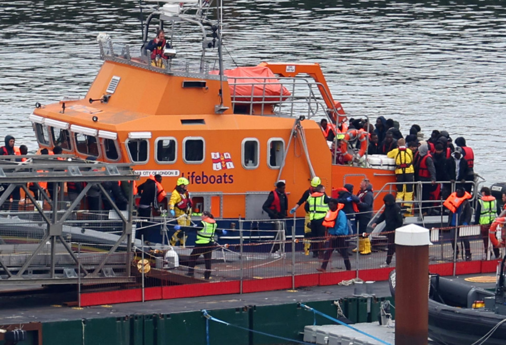 Ľudia, o ktorých sa predpokladá, že ide o migrantov, vystupujú zo záchranného člna v prístave Dover v Británii. FOTO: Reuters