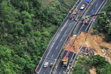 Príslušníci záchranných zložiek zasahujú po zrútení časti diaľnice v juhočínskej provincii Kuang-tung. FOTO: TASR/AP