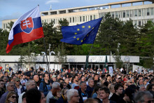 Demonštranti držia vlajky Slovenska a Európskej únie, keď sa  zúčastňujú na proteste proti vládnym zmenám vo verejnoprávnej RTVS v Bratislave. FOTO: Reuters