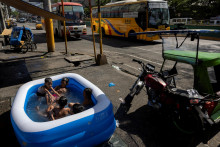Deti plávajú v nafukovacom bazéne počas horúceho dňa v Manile na Filipínach. FOTO: Reuters