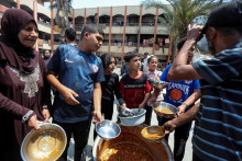 Palestínčania sa zhromažďujú, aby dostali jedlo, ktoré varí World Central Kitchen. FOTO: Reuters